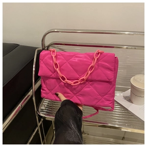 Détail du sac bandoulière rose matelassé avec chaîne élégante et texture en nylon