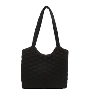 Large black heart-quilted tote bag with long handles for stylish daily commuting