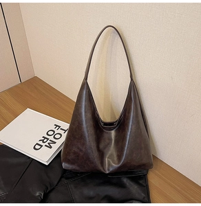 Gros plan du sac hobo en similicuir marron foncé avec une large bandoulière