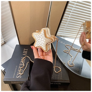 Detail of star-shaped evening clutch with sparkling rhinestones and gold chain strap
