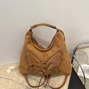 Brown suede hobo bag with leather butterfly patch and adjustable strap for multi-way carry