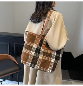 Detail of winter plaid tote bag featuring checkered wool fabric and brown leather straps