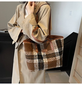 Detail of checkered wool tote bag with brown leather handles and gold metal hardware