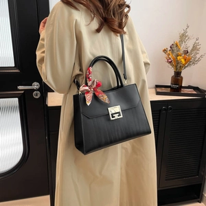 Black textured tote bag with silk scarf accent and gold G-buckle shown on model