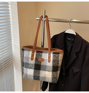 Detailed texture of plaid wool tote bag with premium brown leather handles and gold rivets