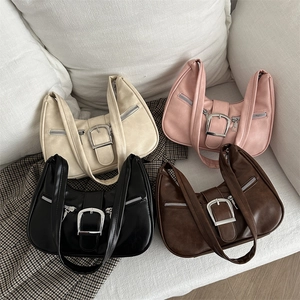 Vintage sichelförmige Handtasche in vier Farben auf einem Sofa für schicken Alltagsstil