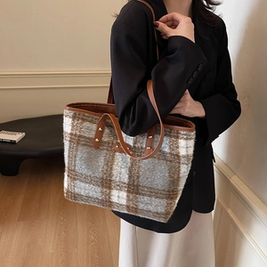 Large plaid wool tote bag with leather handles shown in a lifestyle commuter setting