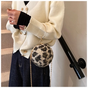 Macro detail of round leopard print evening bag with golden circular handle and chain