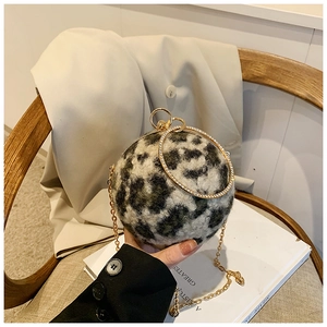 Detail view of leopard faux fur spherical bag with a gold rhinestone handle and chain