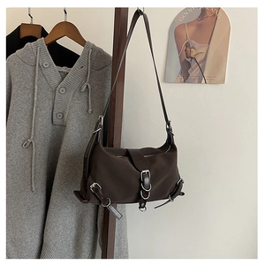 Detailed view of dark brown textured nylon shoulder bag with silver metal buckles