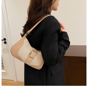 Sac demi-lune beige chic porté avec un blazer noir montrant son profil élégant