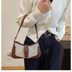 Détail du sac hobo bicolore avec corps en toile, garniture cuir et boucle métal