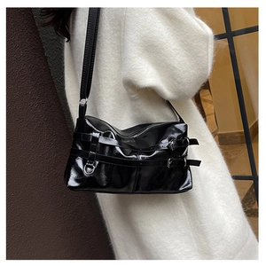 Glossy black PU shoulder bag with silver buckles shown on a soft white sweater
