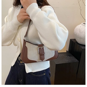 Détail du sac sous le bras rétro en toile crème et finitions en cuir marron