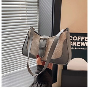Détail du sac croissant gris et blanc avec texture toile et sangle à boucle métal