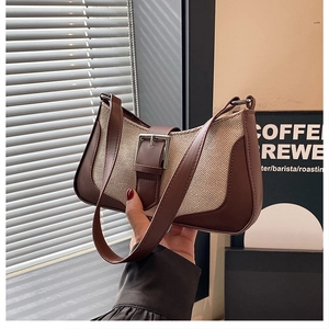 Gros plan du sac croissant rétro en cuir marron et tissu tissé de couleur crème