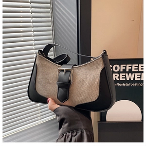 Détail du sac croissant en toile beige avec bordures en cuir noir et boucle argentée