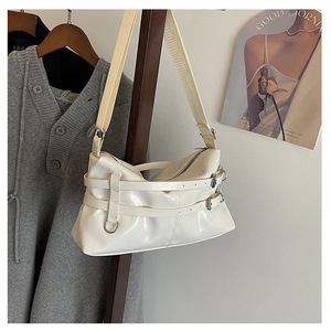 Detail der cremeweißen glänzenden Faltenbag mit Metallschnallen und breitem Gurt