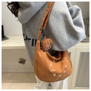 Detail of yellow corduroy hobo bag with letter A embroidery and small coin purse