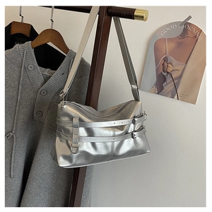 Detailansicht der silbernen Metallic-Schultertasche mit Zierriemen und Metallschnallen