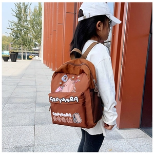 Außenaufnahme eines Kindes mit braunem Capybara-Rucksack und seitlicher Netztasche