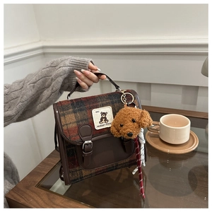 Close-up of retro plaid pattern fabric and leather strap on women's vintage backpack