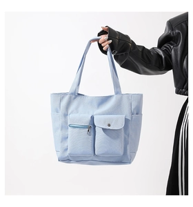 Detail der hellblauen Canvas-Tasche mit doppelten Fronttaschen und praktischen Seitenfächern