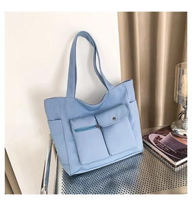 Hellblaue Canvas-Tragetasche mit zwei funktionalen Vordertaschen und Seitenfächern