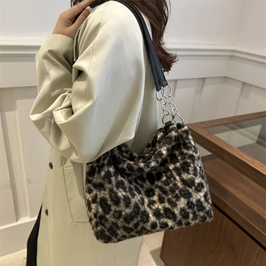 Chic leopard print plush tote bag with silver chain strap worn with a beige coat