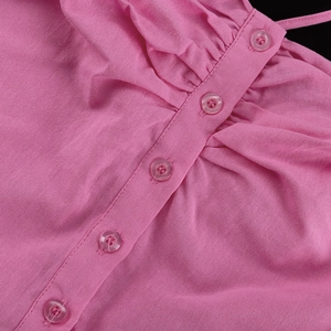 Close-up of pink cotton fabric with pleated textures and five translucent buttons
