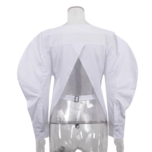 Detail der weißen Baumwollbluse mit V-förmigem Rückenausschnitt und verstellbarer Metallschnalle