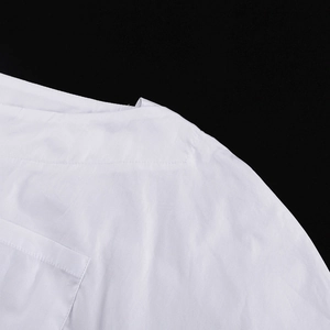 Nahaufnahme der weißen Baumwollbluse mit professionellen Schulternähten und Stoffstruktur