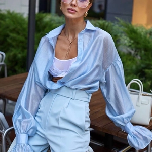 Elegante completo azzurro con camicia trasparente a maniche a sbuffo e pantaloni dritti
