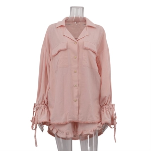 Pink cotton leisure set featuring lapel shirt with flare sleeves and ruffle hem shorts