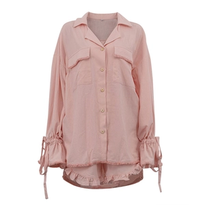 Detailed flat lay of pink cotton lounge set showing wooden buttons and ruffle sleeve cuffs