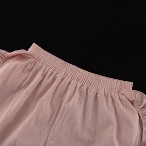 Close-up of pink casual shorts with elastic waist and ruffled edges in soft cotton fabric