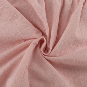 Close-up of pink linen-cotton fabric showing soft woven texture and fiber detail