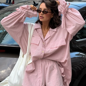 Pink cotton two-piece set featuring flared tie sleeves, flap pockets, and ruffled shorts