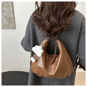 Borsa a spalla marrone a mezzaluna con ciondolo a nuvola su cappotto grigio