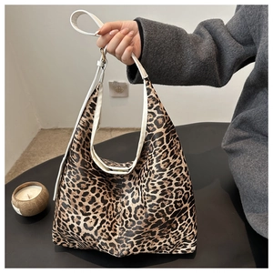 Detail of stylish leopard print tote bag showing the canvas texture and white handle strap