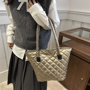 Champagne gold quilted tote bag with large capacity and metallic finish shown on model