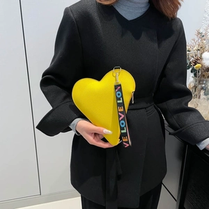 Bright yellow heart-shaped leather crossbody bag with colorful LOVE wrist strap detail