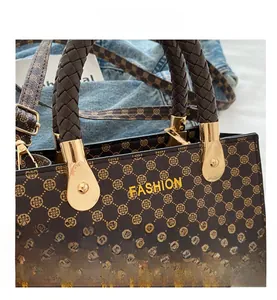 Dettaglio ravvicinato della borsa marrone intrecciata con stampa fashion e fibbia oro