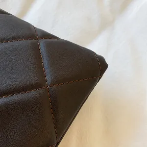 Close-up of diamond quilted brown faux leather texture with detailed stitching