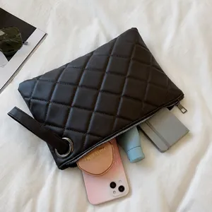 Deep brown quilted clutch bag showing spacious interior for cosmetics and phone