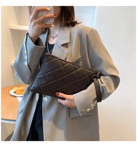 Close-up of black quilted leather clutch featuring classic diamond pattern and metal zipper