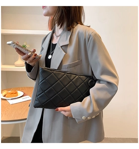 Detail of black quilted leather handbag featuring classic diamond stitching and zipper
