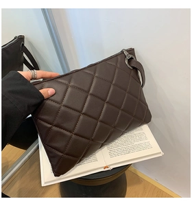 Close-up of a dark brown quilted clutch bag with metallic zipper and wristlet strap