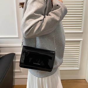 Mini sac carré chic en cuir verni noir avec bandoulière chaîne argentée sur modèle