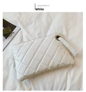 Detail of white quilted PU leather clutch bag with metallic eyelet and wristlet strap